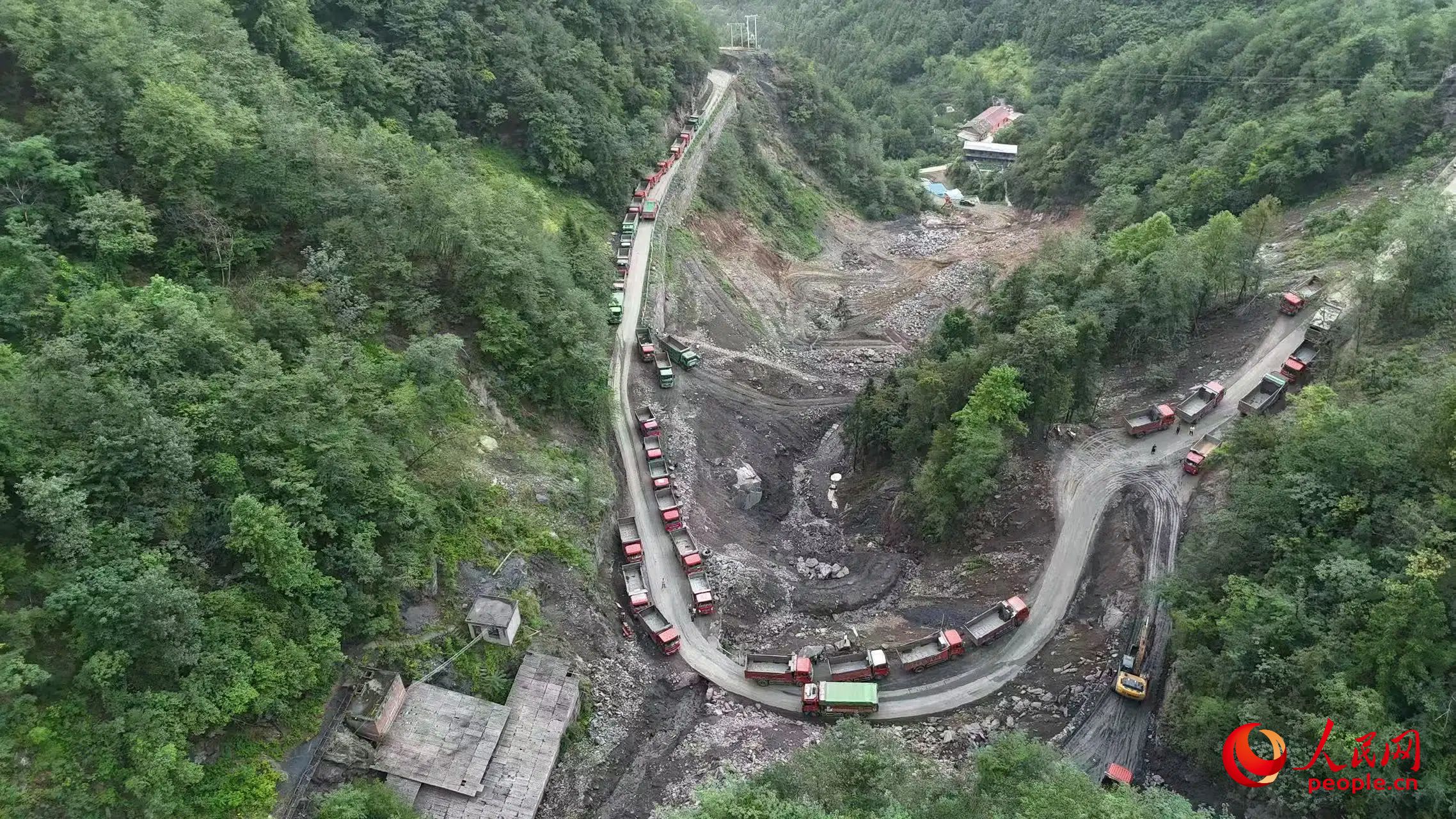 清運礦渣的卡車停在工區(qū)。受訪者供圖