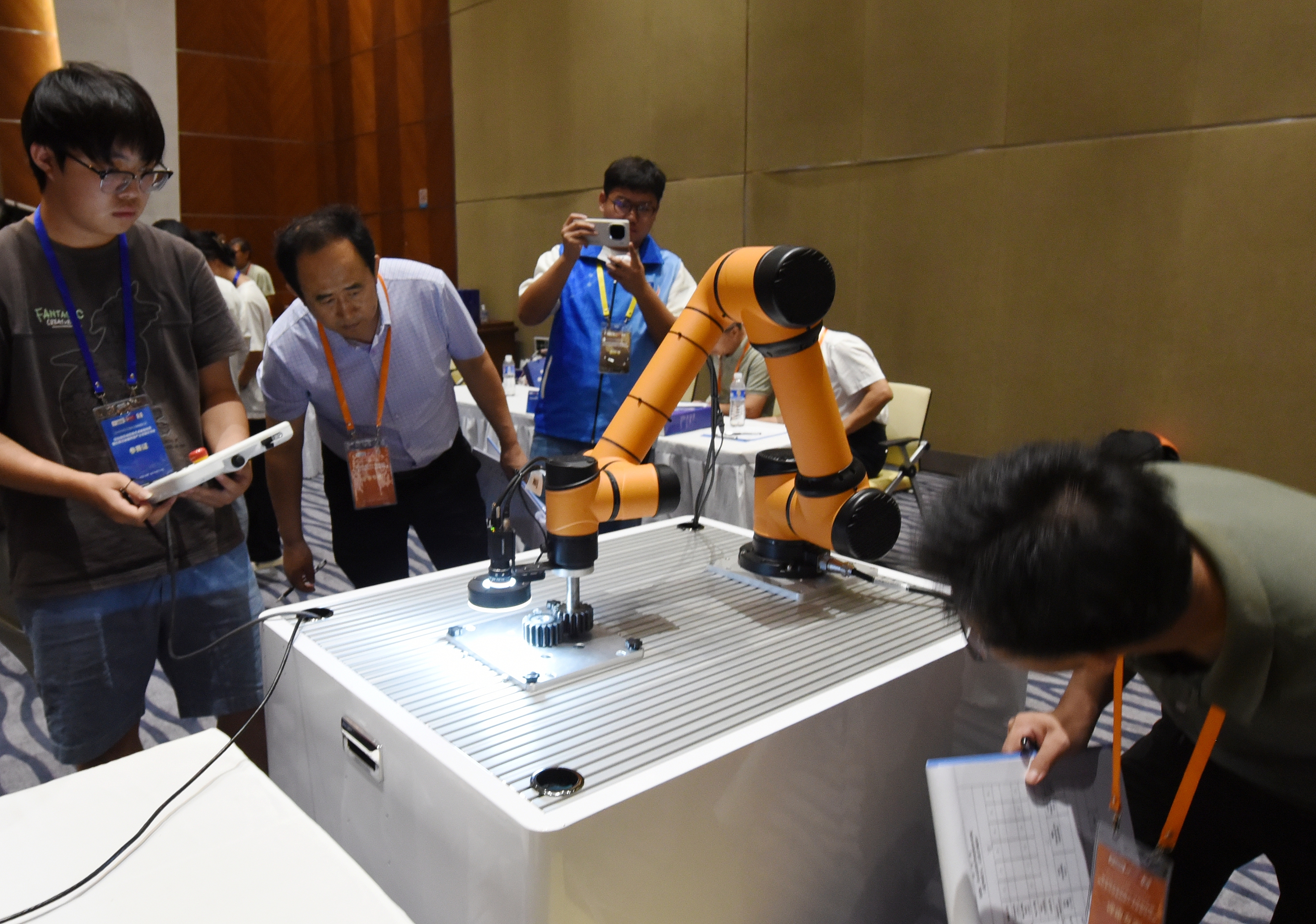 2025年中國大學生機械工程創(chuàng)新創(chuàng)意大賽智能精密裝配賽京津冀魯聯賽現場，評委對參賽選手進行實操調試評比。